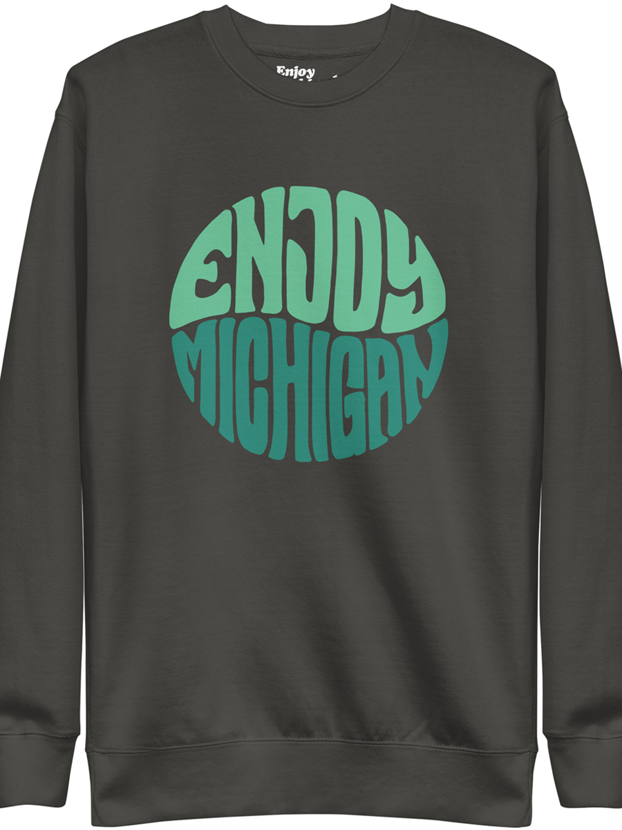 Enjoy Michigan 70's Retro Premium Sweatshirt shown in vintage black with a throwback 70's Enjoy Michigan circular graphic printed on the front. By Enjoy Michigan.