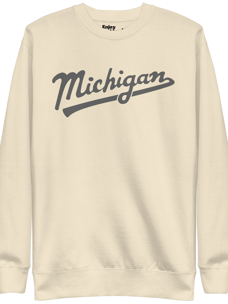Michigan Script premium sweatshirt shown in cream with a gray sport-style script graphic printed on the front. By Enjoy Michigan