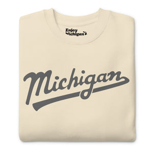 Michigan Script premium sweatshirt shown in cream with a gray sport-style script graphic printed on the front. By Enjoy Michigan
