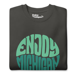 Enjoy Michigan 70's Retro Premium Sweatshirt shown in vintage black with a throwback 70's Enjoy Michigan circular graphic printed on the front. By Enjoy Michigan.